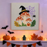 Tableau punch needle amanite sorcière au mur d'une pièce décorée pour Halloween