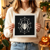 Tableau punch needle araignée blanche tenu en main pour montrer sa taille