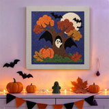 Tableau punch needle arbre ailé accroché au mur dans une déco d'Halloween