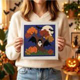 Tableau punch needle arbre ailé tenu en main pour montrer sa taille