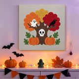 Tableau punch needle arbre au crâne accroché au mur dans une déco d'Halloween