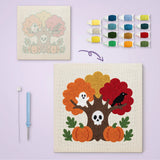 Toile imprimée numérotée posée près du tableau punch needle arbre hanté terminé