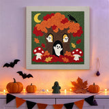 Tableau punch needle arbre habité par des fantômes accroché au mur dans une déco d'Halloween