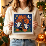 Tableau punch needle arbre hanté tenu en main pour montrer sa taille