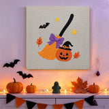 Tableau punch needle balai citrouille accroché au mur dans une déco d'Halloween