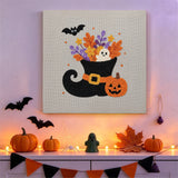Tableau punch needle botte de sorcière accroché au mur dans une déco d'Halloween