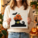 Tableau punch needle trio citrouilles terminé tenu en main pour montrer sa taille