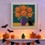 Tableau punch needle vase de fleurs citrouilles accroché au mur parmi des décorations d'Halloween