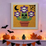 Tableau punch needle cactus tête de mort accroché au mur dans une déco d'Halloween
