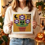 Tableau punch needle cactus crâne tenu en main pour montrer sa taille