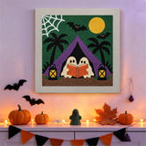 Tableau punch needle fantômes en camping accroché au mur dans une déco d'Halloween