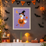 Tableau punch needle canard en costume de citrouille accroché au mur dans une déco d'Halloween