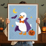 Tableau punch needle canard vampire terminé tenu en main pour montrer sa taille