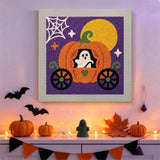 Tableau punch needle carrosse citrouille accroché au mur dans une déco d'Halloween