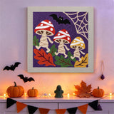 Tableau punch needle champignons momies accroché au mur dans une déco d'Halloween