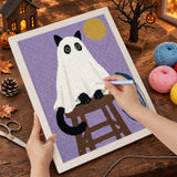 Broderie punch needle en cours sur la toile du chat noir sous son drap blanc, aiguille en main