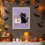 Tableau punch needle chat noir et sac de bonbons accroché au mur dans une déco d'Halloween