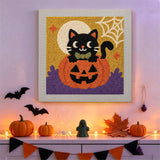 Tableau punch needle chat dans sa citrouille accroché au mur dans une déco d'Halloween