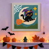 Tableau punch needle chat sur son balai accroché au mur dans une déco d'Halloween