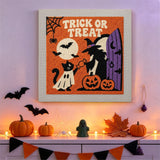 Tableau punch needle chat déguisé en fantôme accroché au mur dans une déco d'Halloween