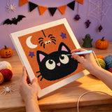Broderie punch needle en cours, aiguille en main, sur la toile du chat noir aux grands yeux