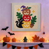 Tableau punch needle chat et potirons empilés accroché au mur dans une déco d'Halloween