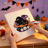 Broderie punch needle en cours, aiguille en main, sur la toile du chat noir au chapeau fleuri