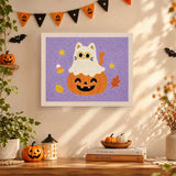 Tableau punch needle chat déguisé en fantôme accroché au mur dans une déco d'Halloween