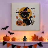 Tableau punch needle chat noir et pleine lune accroché au mur dans une déco d'Halloween