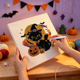 Broderie punch needle en cours, aiguille en main, sur la toile du chat noir devant la pleine lune