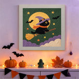Tableau punch needle chat sur balai accroché au mur dans une déco d'Halloween