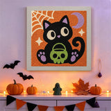 Tableau punch needle chaton noir accroché au mur dans une déco d'Halloween
