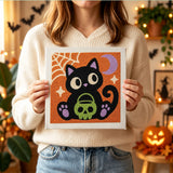 Tableau punch needle chaton au crâne tenu en main pour montrer sa taille