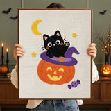Tableau punch needle chaton qui salue terminé tenu en main pour montrer sa taille