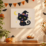 Tableau punch needle chaton noir au chapeau de sorcière accroché au mur dans une déco d'Halloween