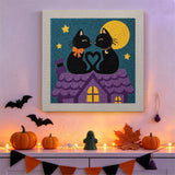 Tableau punch needle chats noirs amoureux accroché au mur dans une déco d'Halloween