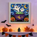 Tableau punch needle chaudron et fantômes accroché au mur dans une déco d'Halloween
