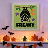 Tableau punch needle chauve-souris tête en bas accroché au mur dans une déco d'Halloween