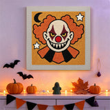 Tableau punch needle clown maléfique accroché au mur dans une déco d'Halloween