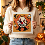 Tableau punch needle clown maléfique tenu en main pour montrer sa taille