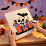 Broderie punch needle en cours sur la toile du crâne et des bougies orange