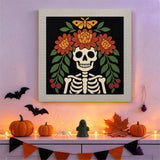 Tableau punch needle squelette fleuri accroché au mur dans une déco d'Halloween