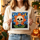 Tableau punch needle crâne en fleur orange tenu en main pour montrer sa taille