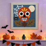 Tableau punch needle crâne décoré accroché au mur dans une déco d'Halloween