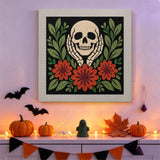Tableau punch needle crâne et dahlias accroché au mur dans une déco d'Halloween