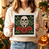 Tableau punch needle crâne et dahlias tenu en main pour montrer sa taille