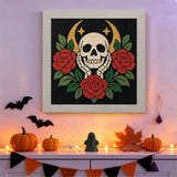 Tableau punch needle crâne et roses rouges au mur dans une déco d'Halloween
