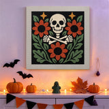 Tableau punch needle tête de mort fleurie accroché au mur dans une déco d'Halloween