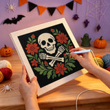 Broderie punch needle en cours, aiguille en main, sur la toile du crâne entouré de fleurs