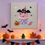 Tableau punch needle cupcake à la cerise accroché au mur dans une déco d'Halloween